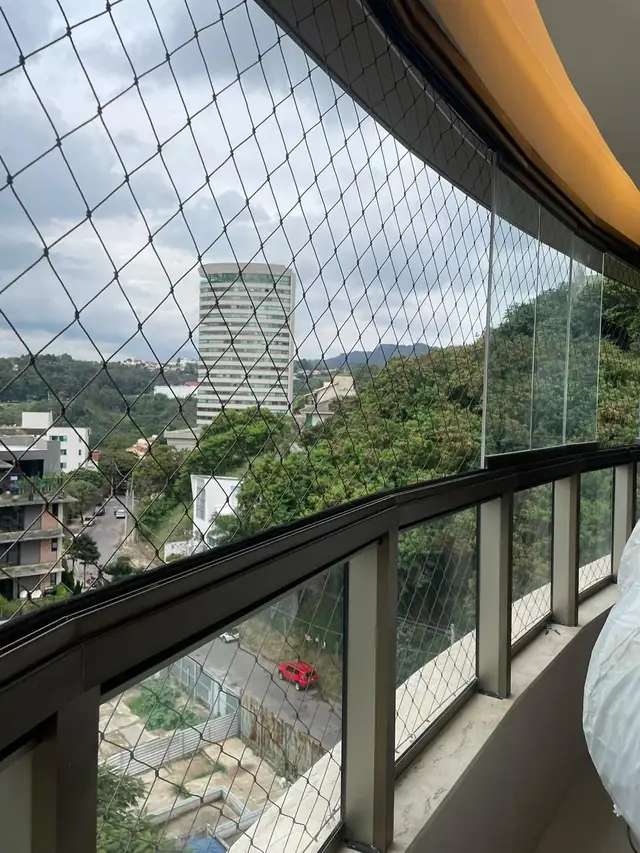 Rede de proteção instalada em sacada de apartamento com vista para a cidade em Belo Horizonte