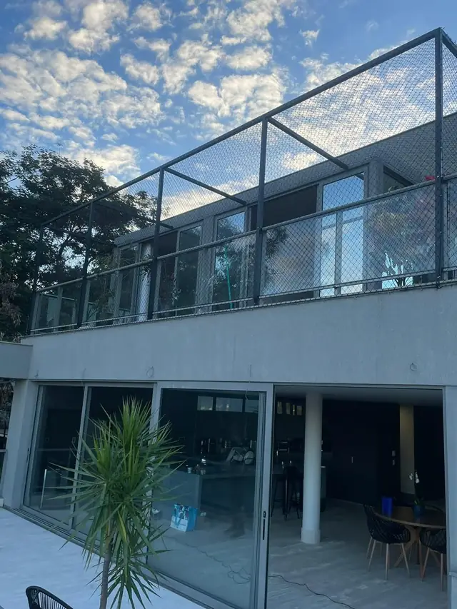 Área de lazer de casa com rede de proteção instalada na parte superior
